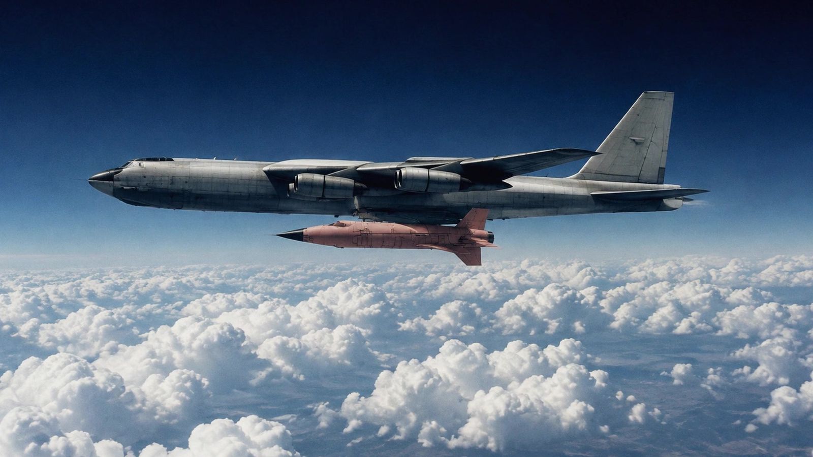 The B-52 mothership carrying the X-15 under its wing above the clouds